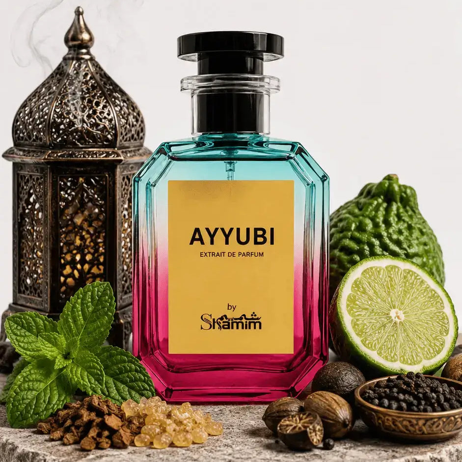 A faceted glass perfume bottle with a black cap, featuring a yellow label that reads 'AYYUBI EXTRAIT DE PARFUM' and 'by Shammim'. The bottle has a blue-to-pink gradient.