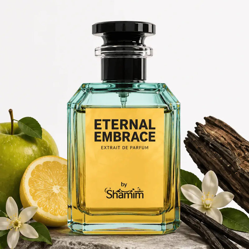 A bottle of Shammim Eternal Embrace Extrait de Parfum displayed on a stone slab with fresh green apple slices, vanilla beans, and white flowers against a clean white background.