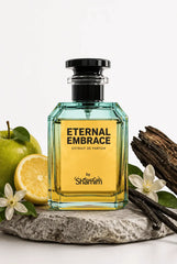 A bottle of Shammim Eternal Embrace Extrait de Parfum displayed on a stone slab with fresh green apple slices, vanilla beans, and white flowers against a clean white background.
