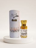 Shamim Attar 101 Night Shams al-Aqsa perfume bottle with a gold cap next to its white cylindrical packaging box, displayed on a white round pedestal.