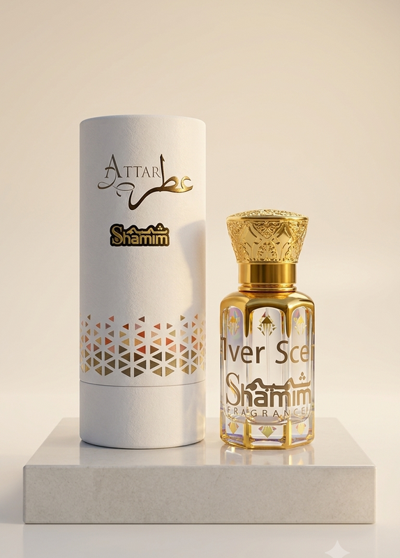 A bottle of Attal Shamim Silver Scent perfume next to its white cylindrical packaging box, both featuring gold lettering and patterns, displayed on a light gray marble block against a warm beige background.