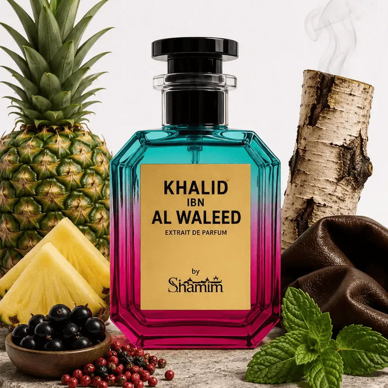 A perfume bottle labeled 'KHALID IBN AL WALEED EXTRAIT DE PARFUM' by Shammim, styled with pineapple, birch wood, berries, mint, and brown fabric on a stone slab against a white background.