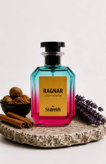 A faceted glass perfume bottle with a black cap, featuring a yellow label that reads 'RAGNAR EXTRAIT DE PARFUM by Shamim'. The bottle has a vibrant blue-to-pink gradient.